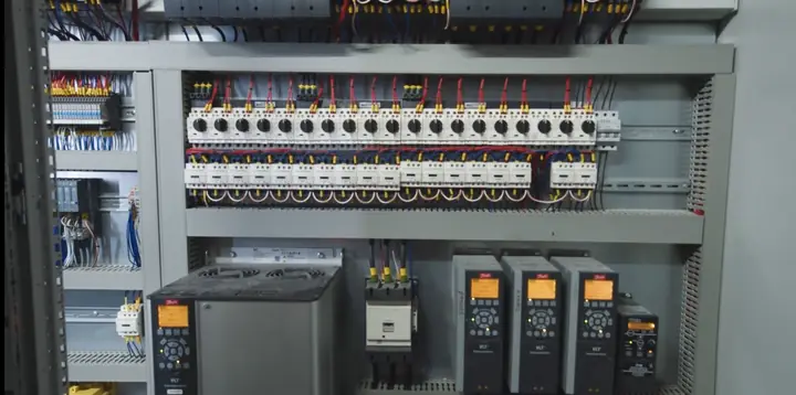 Industrial control panel with rows of motor starters and variable frequency drives