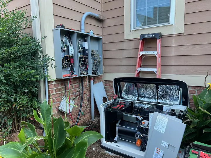 Standby generator and transfer switches being installed on the side of a home